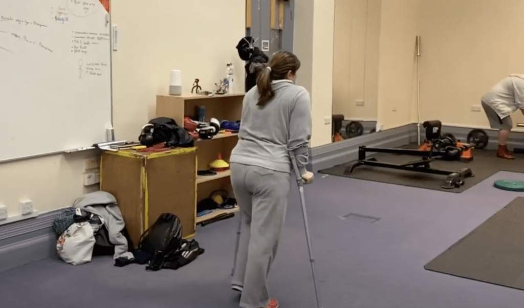 A woman wearing a grey track suit on her mobility programme